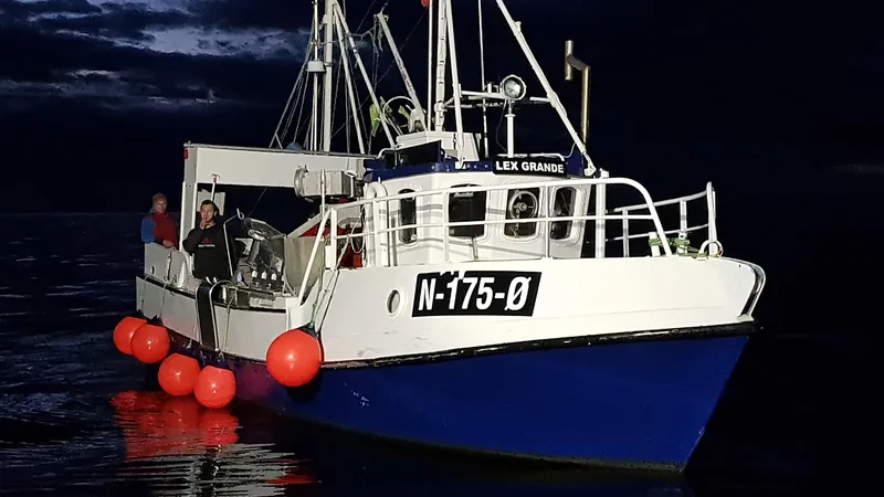 Crew working on the deck of a coastal fishing boat at dusk